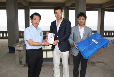 石川副支部長(左)も加わっての記念撮影。石川副支部長の手には贈呈した資源ごみ分別用のネット状の袋が。