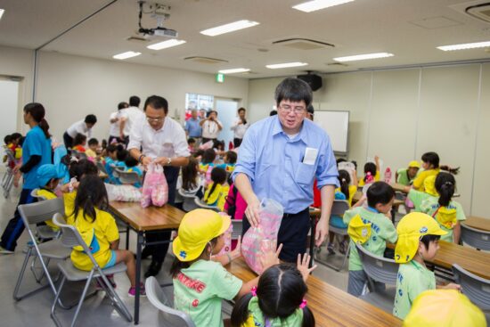 ④ 終了後に袋いっぱいのお菓子を受け取る園児たち。